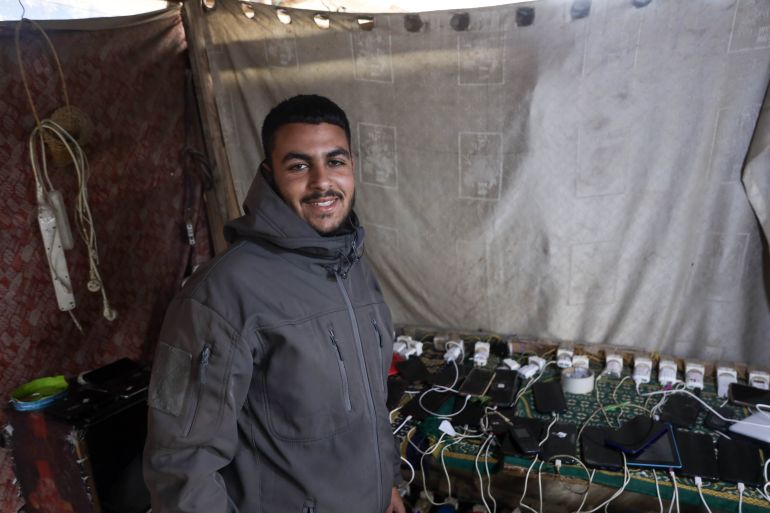 Gazans use drained phones as their only light source in darkness.